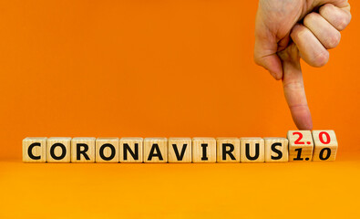 Covid-19 coronavirus 2.0 symbol. Doctor turns cubes and changes words coronavirus 1.0 to coronavirus 2.0. Beautiful orange background copy space. Medical Covid-19 coronavirus 1.0 or 2.0 concept.