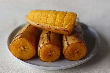 Steamed plantain banana, four haves stacked on a plate