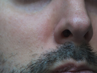 Nose and mouth of a bearded man close up 