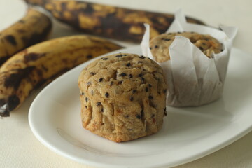 Plantain muffins. A healthy snack with extra ripe plantains, whole wheat flour and sesame seeds as the ingredients. Shot with muffins inside parchment paper cups