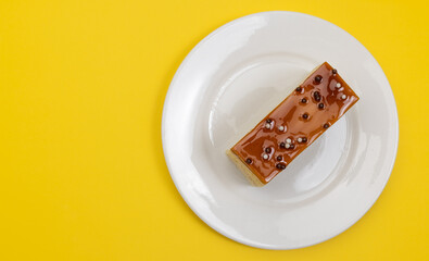 Top view of Caramel Three Milk Cake or Tres Leches Pan on plate against yellow background....