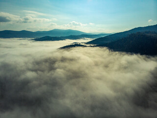 Obraz premium Aerial view of clouds and fog over mountains hills