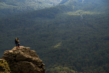 Couple Enjoying Mountain View on Rock Peak. Amazing Mountain Scenery