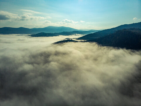 Aerial view of clouds and fog over mountains hills