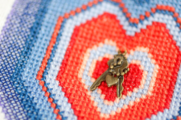 Macro of a embroidery heart with miniature keys. Love concept background. Valintine's day