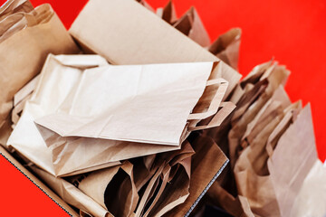 Lots of paper bags in a cardboard box. Biodegradable bags with a small handle. Selective focus....