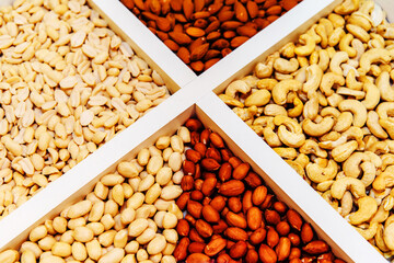 Nuts of different types on a wooden tray. Ingredient for confectionery and culinary products. Close-up