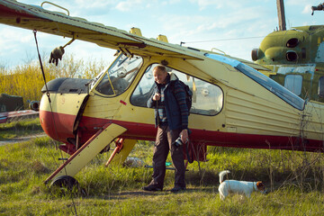 A middle-aged man near an old abandoned Soviet plane. Airplane on the field of the old airport