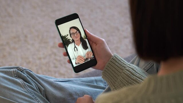 Female patient talking doctor on smartphone by video calling, distance consulting with psychotherapist in white coat . Telemedicine, remote healthcare services concept. Vertical view. 4k footage