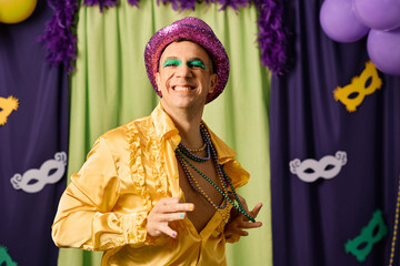 Happy man in colorful Mardi Gras carnival costume had fun on a party.