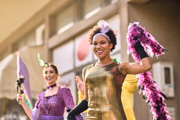 Cheerful black woman has fun on Mardi Gras street carnival while wearing a costume.