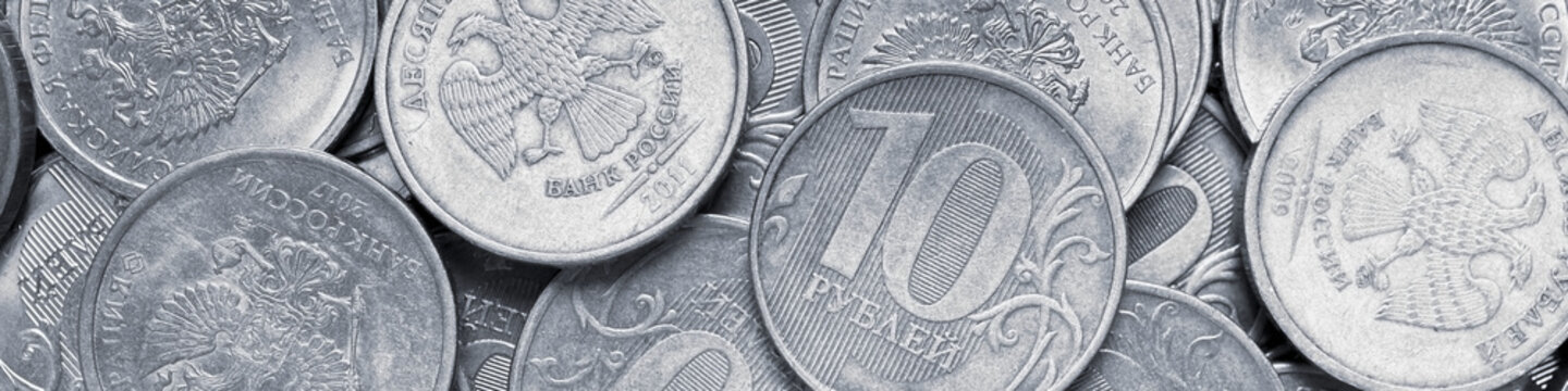 Surface of many Russian coins of 1 one ruble. Gray and purple tinted banner. Light headline on the theme of economy, finance and the central bank of Russia. Macro