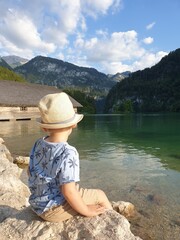 The boy is sitting on a rock , K&ouml;nigssee, Berchtesgaden