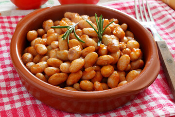 Bowl of stewed beans with tomato sauce and various flavors. 