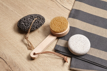 Wooden brush and pumice stones on wooden background
