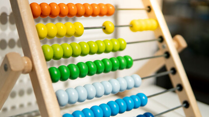 Wooden calculating beads on rainbow abacus for number calculation. Mathematics learning concept