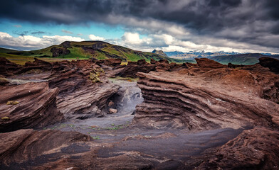 Stunning Iceland nature landscape.  Scenic Image of Iceland. red sandy Volcanic rock formation near Dyrholaey coast of Iceland, Europe. Typical Icelandic scenery in a cloudy day.