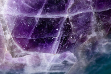 A closeup of a raw amethyst crystal under the lights with blurred edges