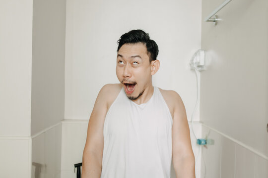 Funny face expression of Asian man try to poop in the toilet.