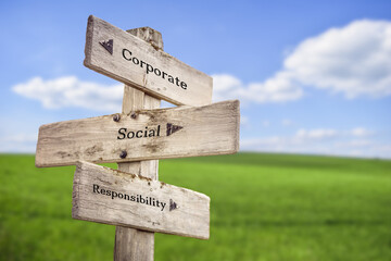 corporate social responsibility text quote on wooden signpost outdoors on green field.