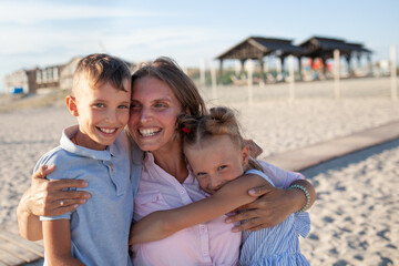 Portrait of happy mother and children, kids hugging mom