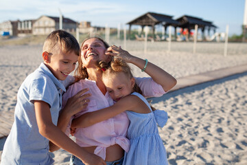 Fototapeta na wymiar Portrait of happy mother and children, kids hugging mom