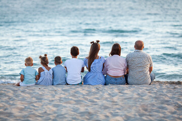 portrait of a big happy family, parents with children are relaxing on the seashore