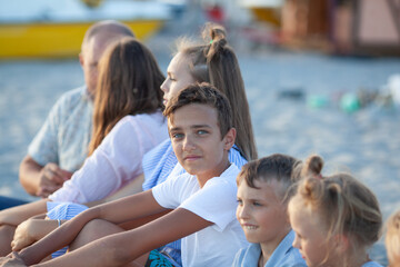 portrait of a big happy family, parents with children are relaxing on the seashore