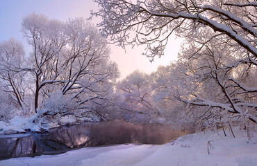 Winter frosty scene with forest river and snow covered trees