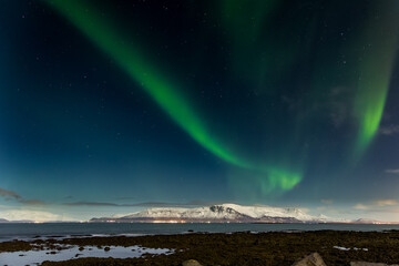 Northern Lights over the snowcapped Mount Esja in the Icelandic capital, Reykjavík