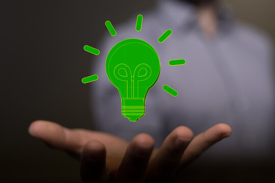 Hands holding green nature in the light bulb