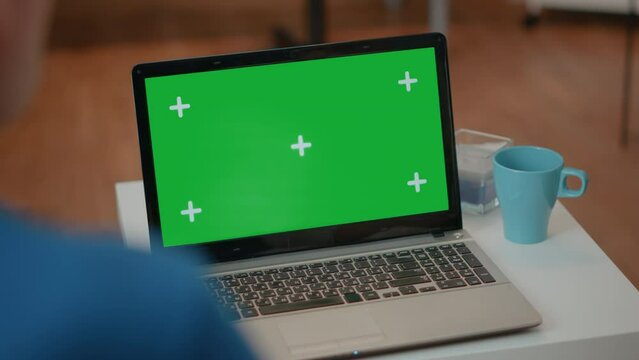 Senior man and woman looking at green screen on laptop. Elderly couple using blank copy space with isolated chroma key template and mock up background on computer. Technology on display