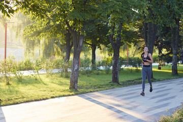 Morning jogging, young fitness lady. Workout in the park outdoors