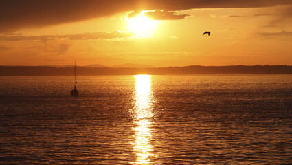 A sailing boat on the Puget Sound during a breathtaking sunset in the evening in Washington