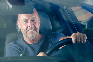 confident man driving a car on sunny summer day