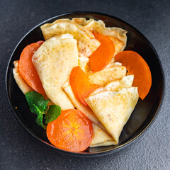 thin pancake persimmon crepe Shrovetide holiday Maslenitsa sweet dessert breakfast pancakes food snack on the table copy space food background 