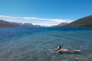 Fototapeta na wymiar Person swimming on the lake in the mountains 