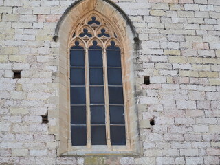 Fototapeta na wymiar pequeña ventana acristalada de arco ojival de la iglesia de san francisco de montblanch, tarragona, españa, europa