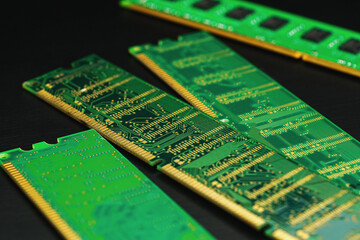 Computer Random Access Memory (RAM) chips on black wooden floor.	