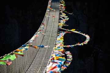 Suspension bridge in the Himalaya mountains in Nepal with prayer flags. Tamang Heritage Trail and Langtang trek day 4 from Nagthali to Lingling
