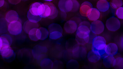 abstract background with bokeh of purple, blue, and red lights against a black background