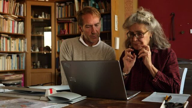 Man giving computer lessons to senior lady.