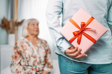 Gift for mother. Young caucasian daughter gives her mom a gift