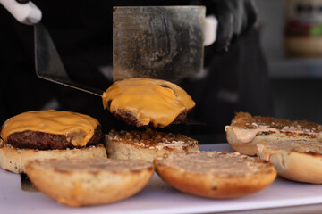 Chef preparing cheese burgers on a table
