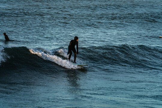 Surfer catching waves in cold water in winter, cold hawaii, norre vorupor, Klitmoller and Hanstholm, denmark