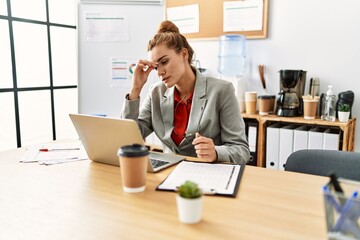 Young woman business worker stressed using laptop working at office