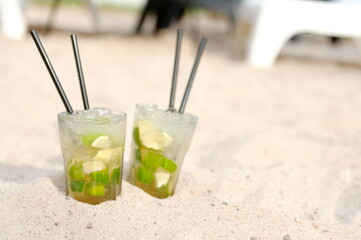 Sommer, Sonne, Strand mit Caipi, Caipirinha im Sand mit Strohhalm