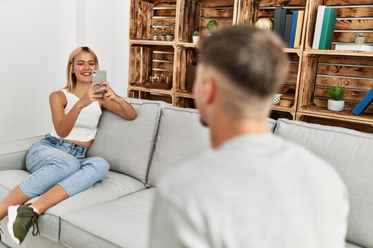 Woman making photo to her boyfriend using smartphone at home.