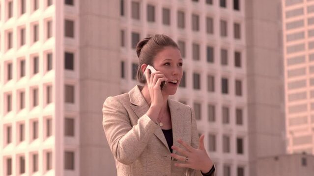 Businesswoman excitedly talks on her cellphone