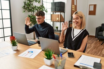 Two business workers smiling happy having video call at the office.
